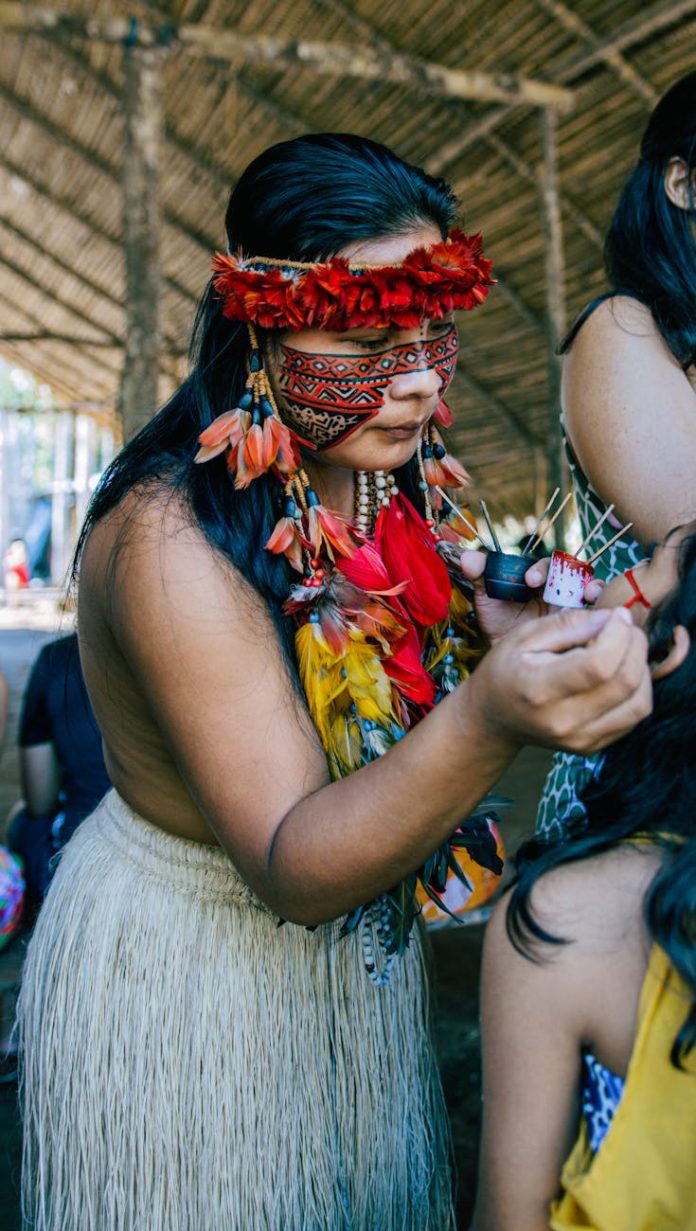 indigenous woman in traditional attire painting face