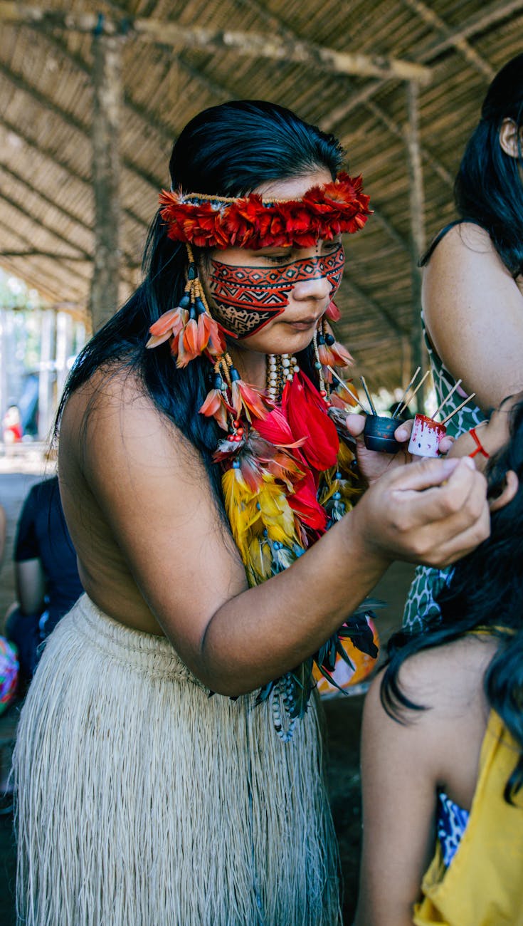 indigenous woman in traditional attire painting face