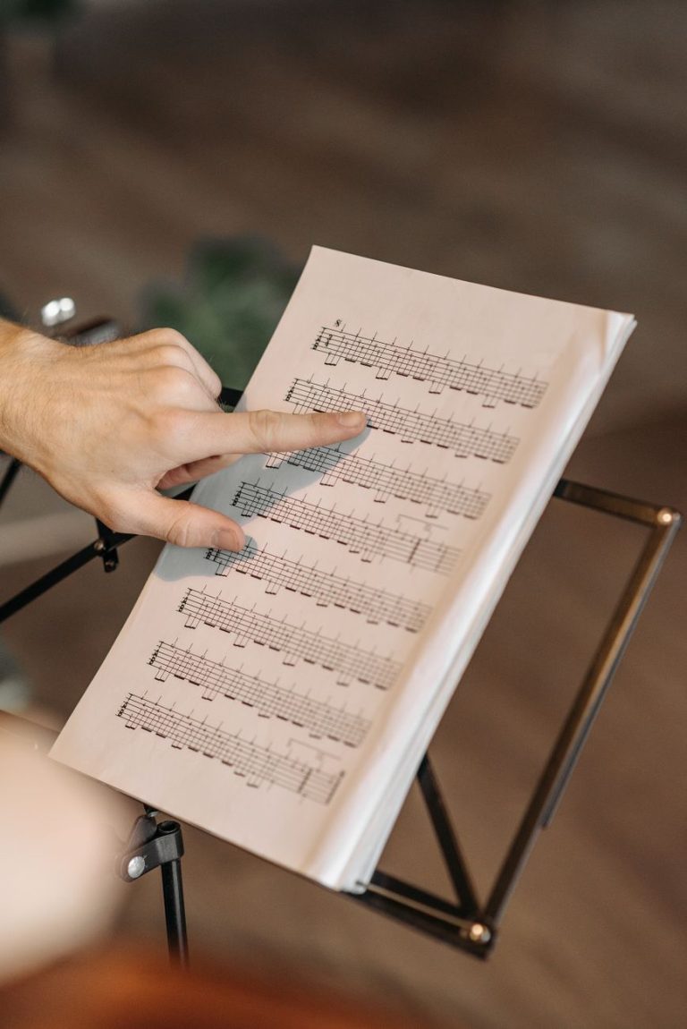 a person pointing on a music sheet