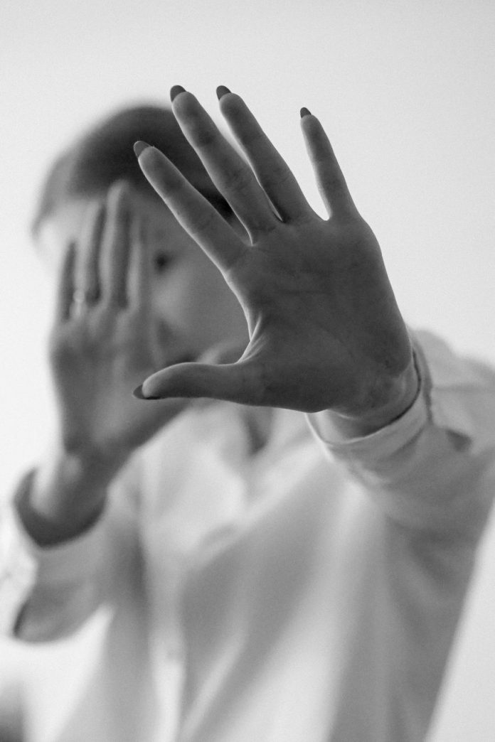 monochrome hands blocking camera close up